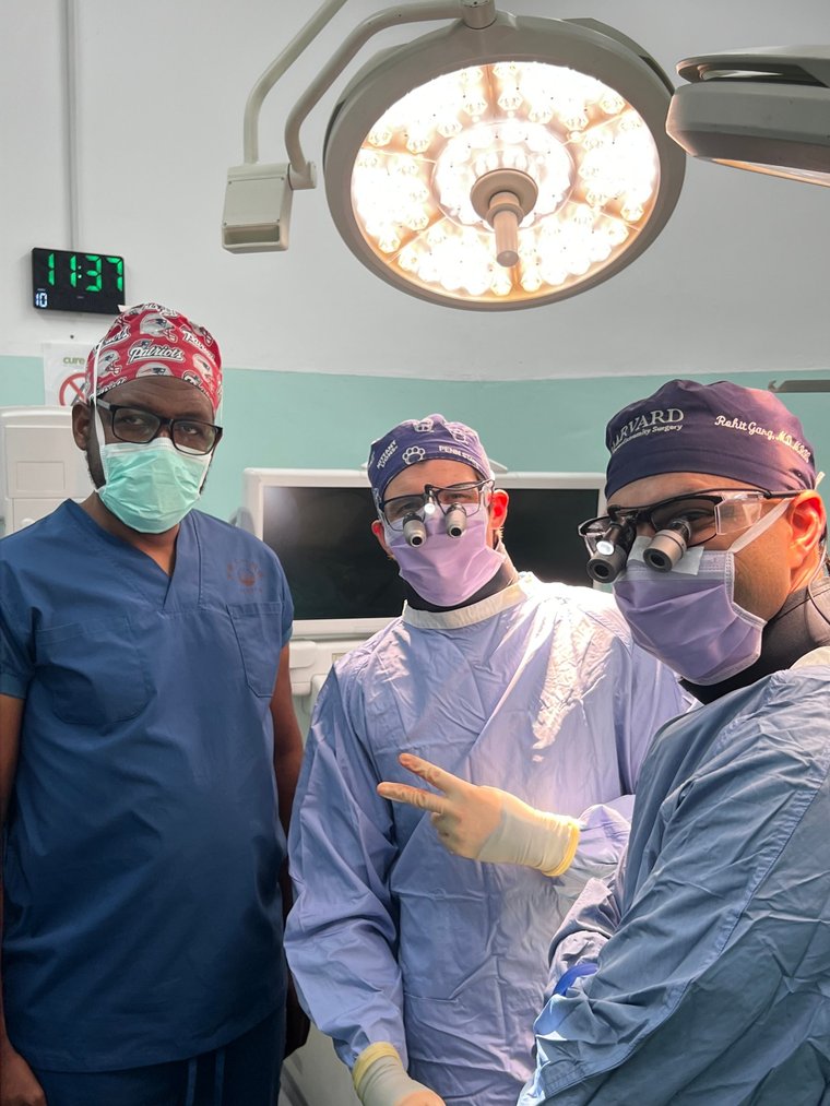 Dr. Timothy J. Irwin in the operating room with the surgical team at Beit CURE International Hospital in Zambia, wearing surgical loupes during a hand and brachial plexus mission.